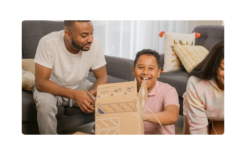 Excited child opening an eCommerce package with family, showcasing customer loyalty and the joy of online shopping.